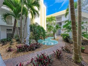 une cour avec une piscine dans un bâtiment avec des palmiers dans l'établissement Penthouse Shores 307, à Clearwater Beach