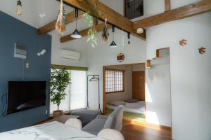 een woonkamer met een bank en een tv bij ウィステリア in Teshikaga