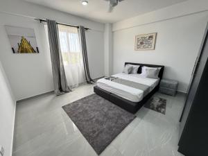 a white bedroom with a bed and a rug at Ocean waves in Mombasa +22 photos
