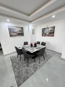 a dining room with a table and chairs in a white room at Ocean waves in Mombasa