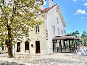 a white building with a tree in front of it at Passeio Sintra Collection-Soft Opening in Sintra