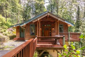 a cabin in the woods with a porch and a deck at Peace of Mind at Hound Ears in Valle Crucis