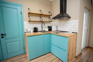 a kitchen with blue cabinets and a sink at My Home Apartments in Berehove