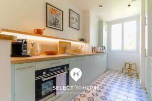 a kitchen with a sink and a stove at SELECT'soHOME - T3 vue mer - Centre ville avec place de parking - CALYPSO in Le Lavandou