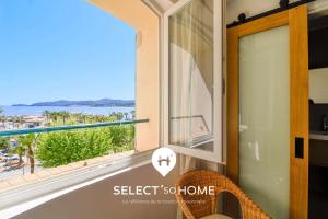 a room with a window with a view of the ocean at SELECT'soHOME - T3 vue mer - Centre ville avec place de parking - CALYPSO in Le Lavandou
