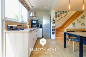a kitchen with a refrigerator and a dining table at SELECTsoHOME - Cocon avec jardin, plancha et parking privé ! - Résidence avec piscine et tennis - CASITA in Bormes-les-Mimosas