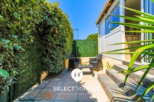 a patio with two chairs and a table next to a hedge at SELECTsoHOME - Cocon avec jardin, plancha et parking privé ! - Résidence avec piscine et tennis - CASITA in Bormes-les-Mimosas
