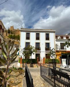 a white building with a fence in front of it at Casa Alamanda Moclin in Moclín