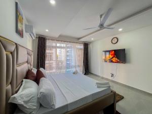 a bedroom with a bed and a clock on the wall at Madzo Holiday homes in Mombasa