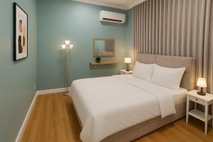 a bedroom with a large white bed and a mirror at شقة 8 واسعة وأنيقة ثلاث غرف نوم in Al Khobar
