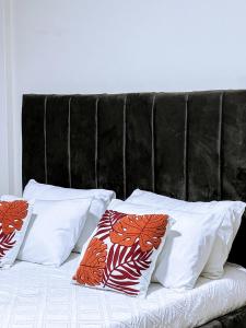 a bed with four pillows on top of it at Eliana Apartment in Kampala