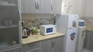 a kitchen with a counter with a microwave and a refrigerator at سوما للشقق المفروشه Soma apt in Al Madinah
