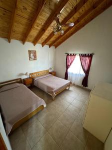 a bedroom with two beds and a window at Cabañas Paihuen in Trevelin