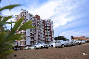 a row of cars parked in front of a building at Eliana Apartment in Kampala