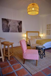 Cette chambre comprend deux lits, une chaise et une table. dans l'établissement MM Good Times, à Gansbaai