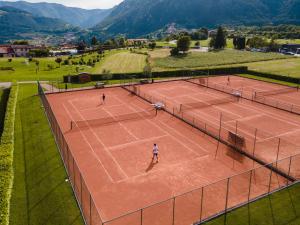 three people playing tennis on a tennis court at Hotel Residence La Pertica in Tremosine Sul Garda