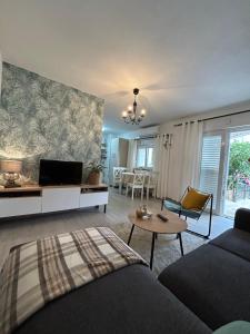a living room with a couch and a table at Apartman Dukić in Okrug Gornji