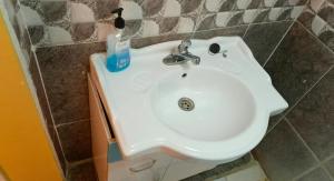 a bathroom sink with a bottle of soap on it at Sandfields Lodwar Resort and Spa in Lodwar +10 photos