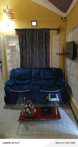 a blue couch in a living room with a table at Sandfields Lodwar Resort and Spa in Lodwar