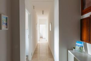 a hallway in a house with white walls and white floors at Wellness Holiday Home - Self Check-in & Access in Brunate