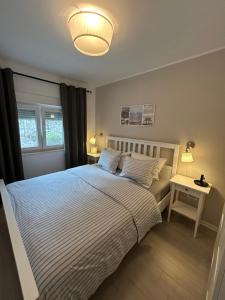 a bedroom with a bed with a white bedspread at Apartman Dukić in Okrug Gornji