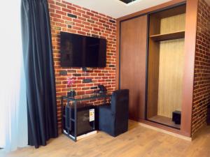a living room with a brick wall with a tv at ABMGreen in Tangier