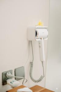 un telefono bianco appeso a una parete accanto a un telefono di NaSya Villa Ubud ad Ubud