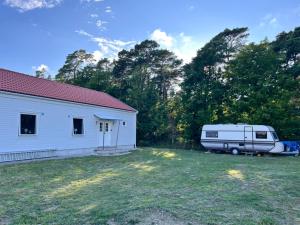 a white trailer parked in a yard next to a house at Helt hus, nybyggt nära Visby in Visby