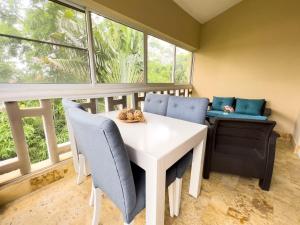 a dining room with a white table and blue chairs at Boca Chica Resort 635 in Boca Chica