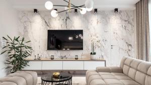 a living room with a couch and a tv on a wall at LuxHome by Lake Neusiedl with Jakuzzi in Fertőszentmiklós
