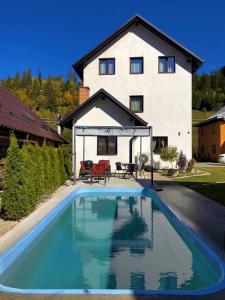 a swimming pool in front of a house at Casa Ambra in Sadova