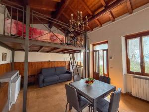 a living room with a dining table and a loft bed at Welcome traveller Benaco Chalet in Torri del Benaco +15 photos