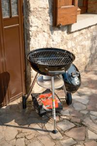 a charcoal grill sitting in front of a building at Welcome traveller Benaco Chalet in Torri del Benaco