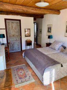 a bedroom with two beds and a table and a door at La Maison Provençale in La Roquebrussanne