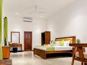 a bedroom with a bed and a desk in it at Grandpa's villa Jaffna in Jaffna +34 photos