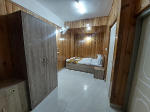 甘托克Hotel Rashak - Mg Marg的带床和木墙的卧室