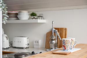 a kitchen counter with a coffee cup on a cutting board at Loft with lake views in Turku! in Turku