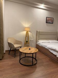 Un dormitorio con una cama, una mesa y una silla. en NCRstay, en Greater Noida
