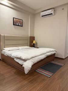 1 dormitorio con 1 cama y aire acondicionado en la pared en NCRstay, en Greater Noida