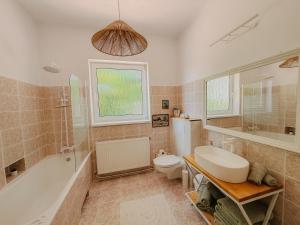 a bathroom with a toilet and a tub and a sink at Casa RusTic in Turda +21 photos
