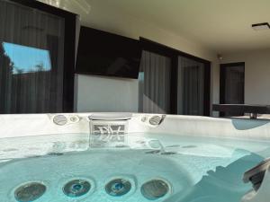 a jacuzzi tub with a chair in it at LuxHome by Lake Neusiedl with Jakuzzi in Fertőszentmiklós +57 photos