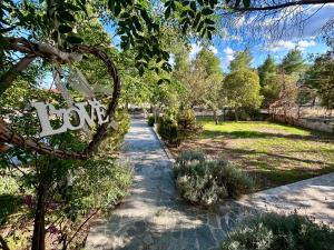 a garden with a sign hanging from a tree at Daydream Nature Home - Hot Tub & Cinema Experience in Oinóï