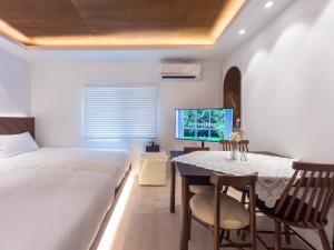 a bedroom with a bed and a table and a tv at 하루재 in Seoul