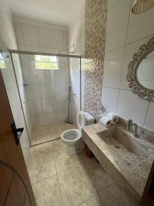 une salle de bain avec toilettes, lavabo et miroir dans l'établissement Casa de Boneca, à Prado