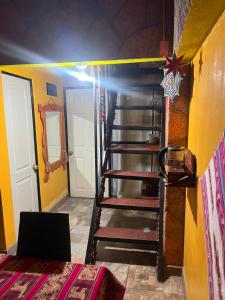 a spiral staircase in a room with yellow walls at Estrella Ancestral 1 in San Pedro de Atacama +1 photo