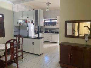 a kitchen with white cabinets and a mirror at Casa Doce Refugio - ao lado do centro in Bom Jesus da Lapa
