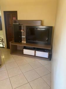 TV de pantalla plana en un centro de entretenimiento en Casa Doce Refugio - ao lado do centro, en Bom Jesus da Lapa