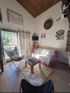 un salon avec un canapé et une horloge au mur dans l'établissement Coup de coeur - Centre station, Proche pistes de ski, à Les Deux Alpes