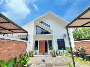 a child standing in front of a white house at Yustien Homestay Jogja 3 Bedroom - Entire House in Bantul