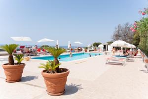a pool with palm trees inront of a resort at I giardini di Santomaj in Leporano